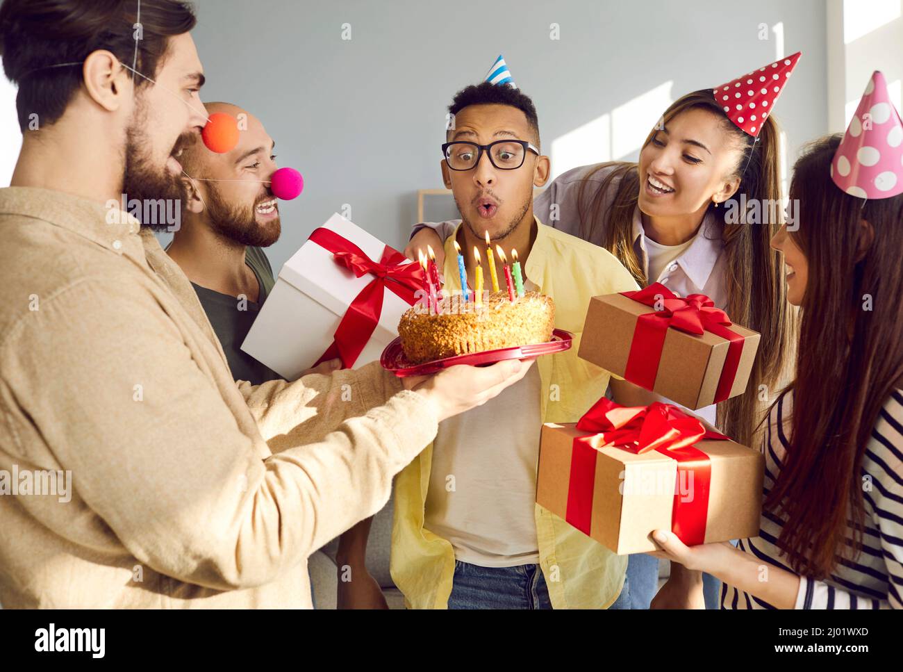 Smiling multiracial friends greeting mate with happy birthday Stock Photo
