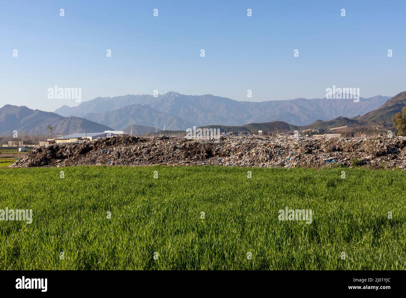 A massive garbage dump solid waste site in agriculture fields Stock Photo