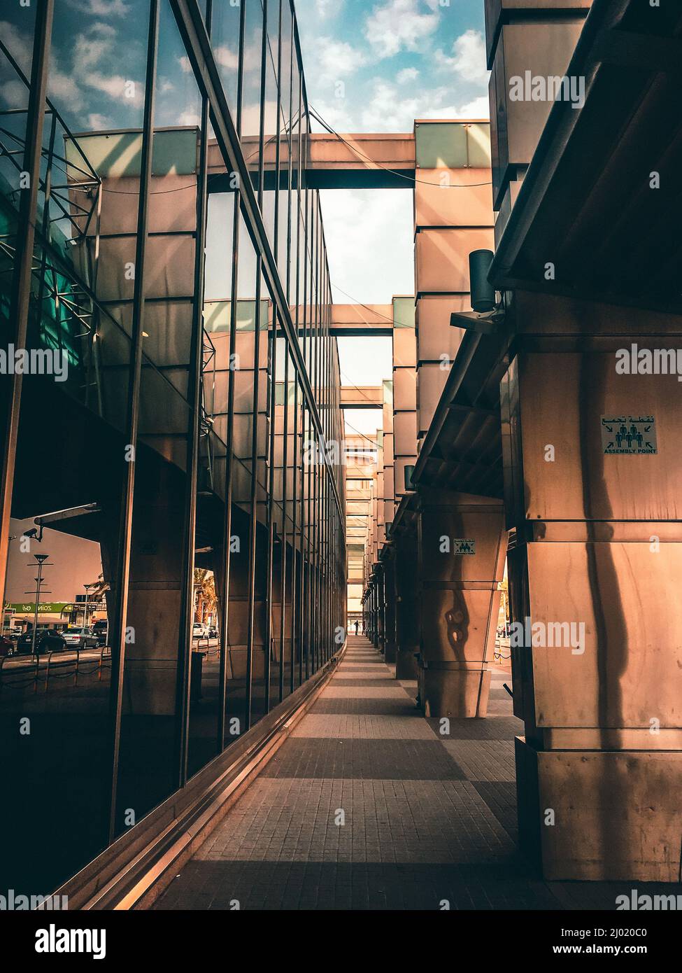 Vertical shot of a small alley between a bridge and a glass building ...