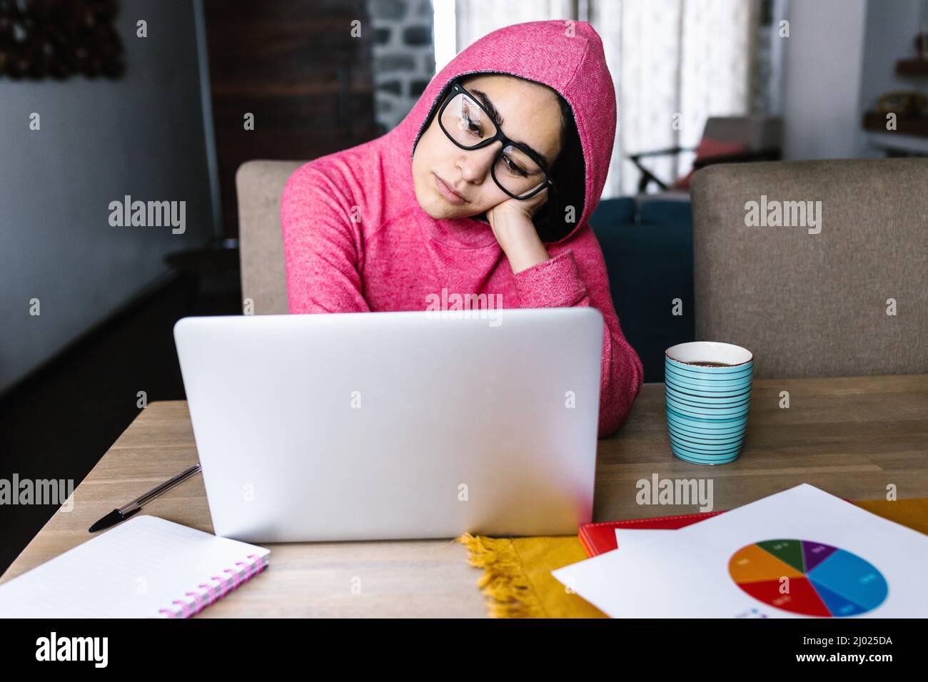 Latin woman in front of her laptop staring at the screen, bored, sleepy ...