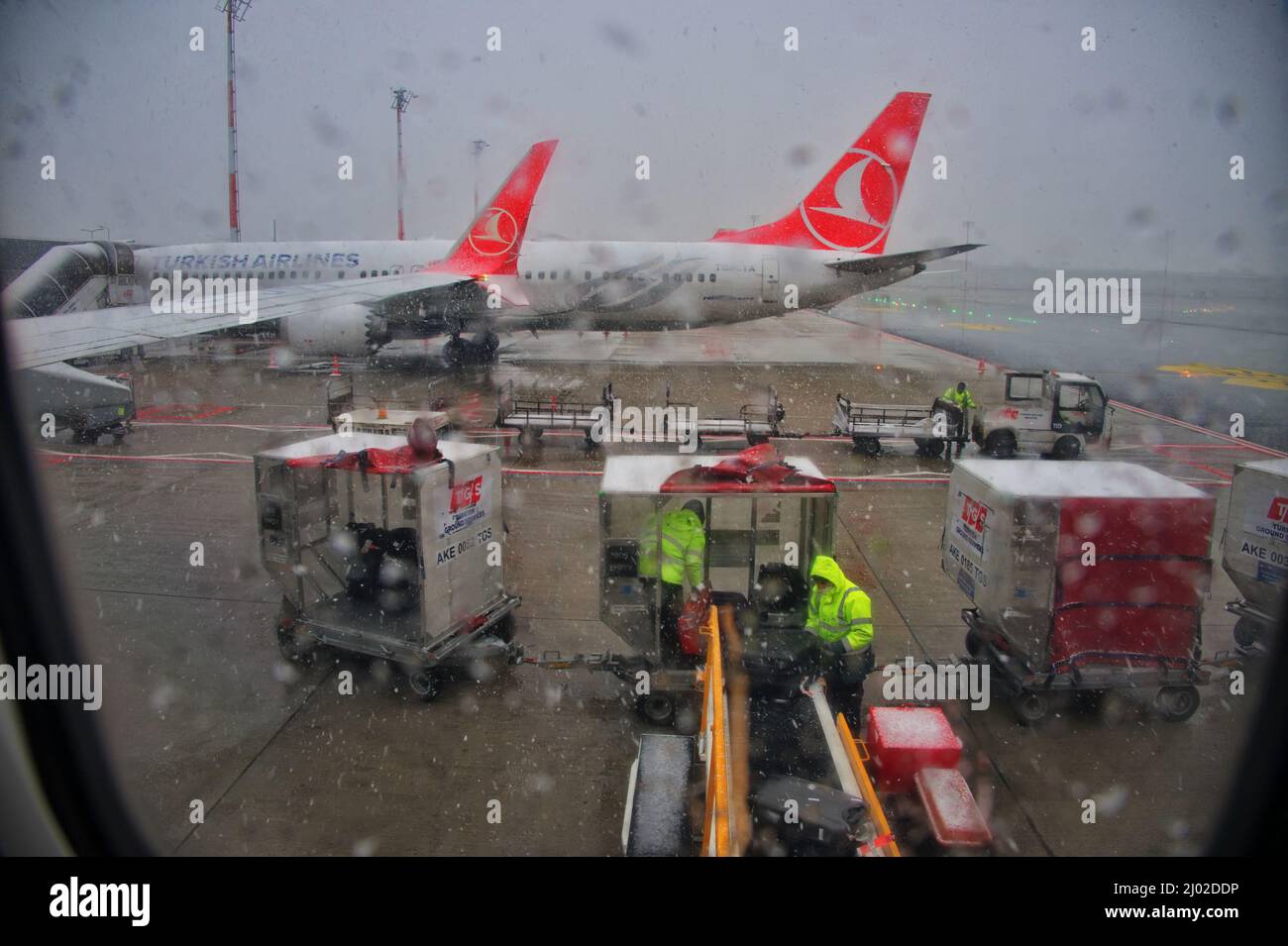 Loading luggage on a plane during rainy day - view from window Stock Photo
