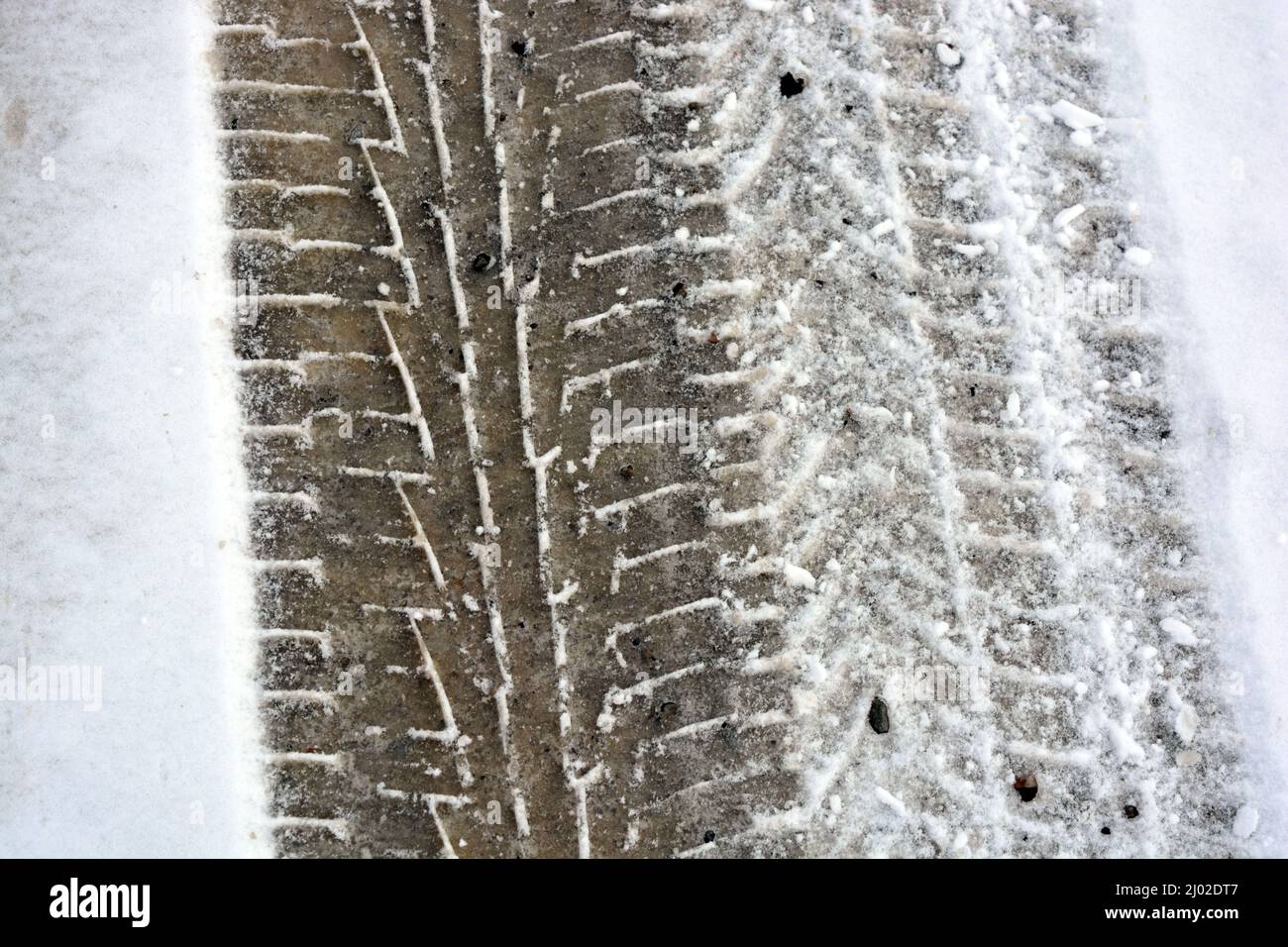 Tracks from car wheels, passing cars on a snowy and melting winter road ...