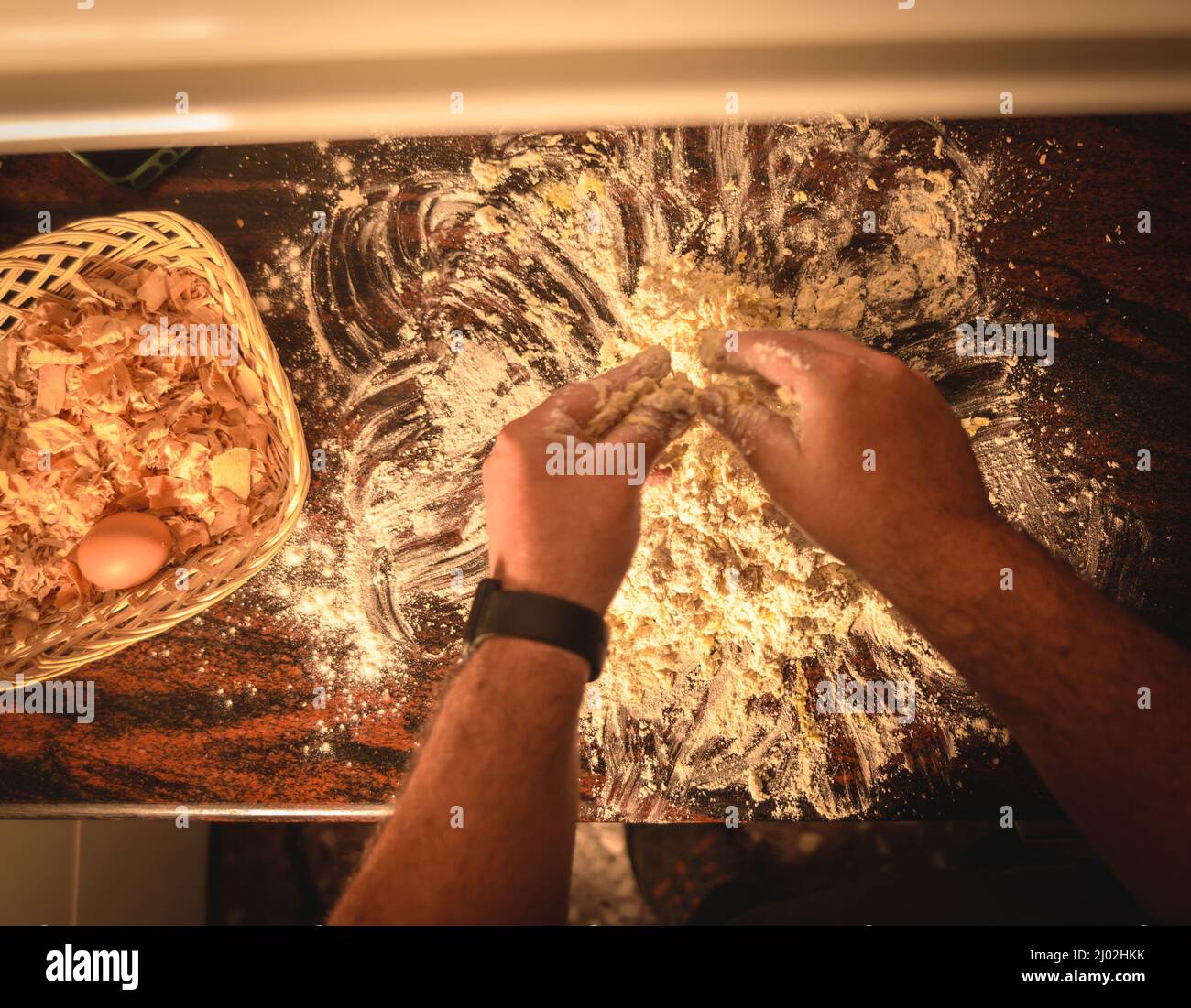 Top view of the professional chef using his hands for grounding a dough ...