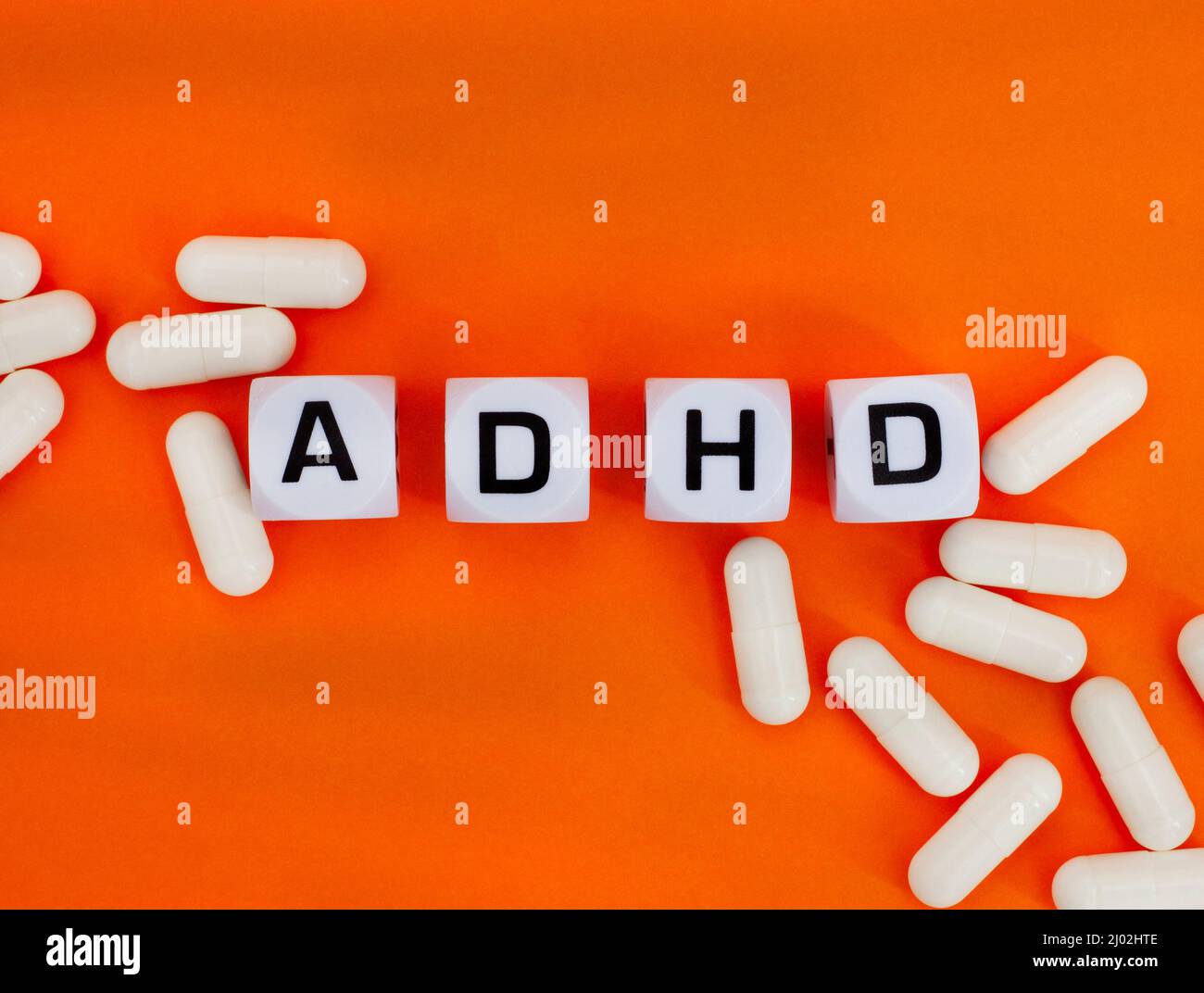 ADHD in letter dice on orange background, the color of ADHD awareness