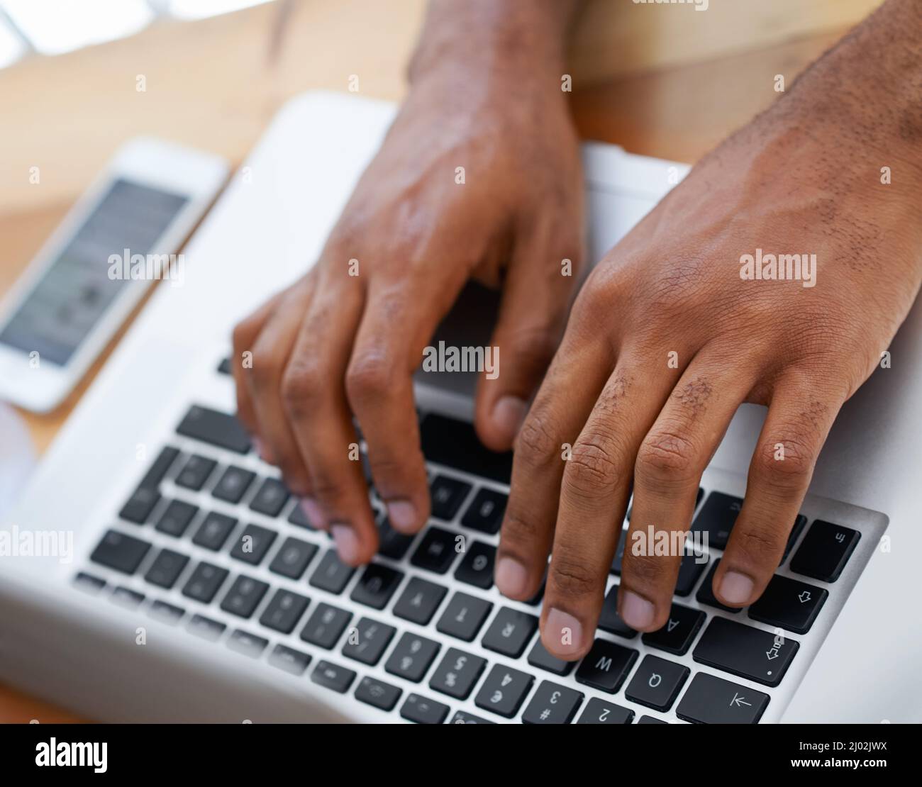 Filling in the blanks. Cropped view of a businessmans hands as he types on his laptop. Stock Photo