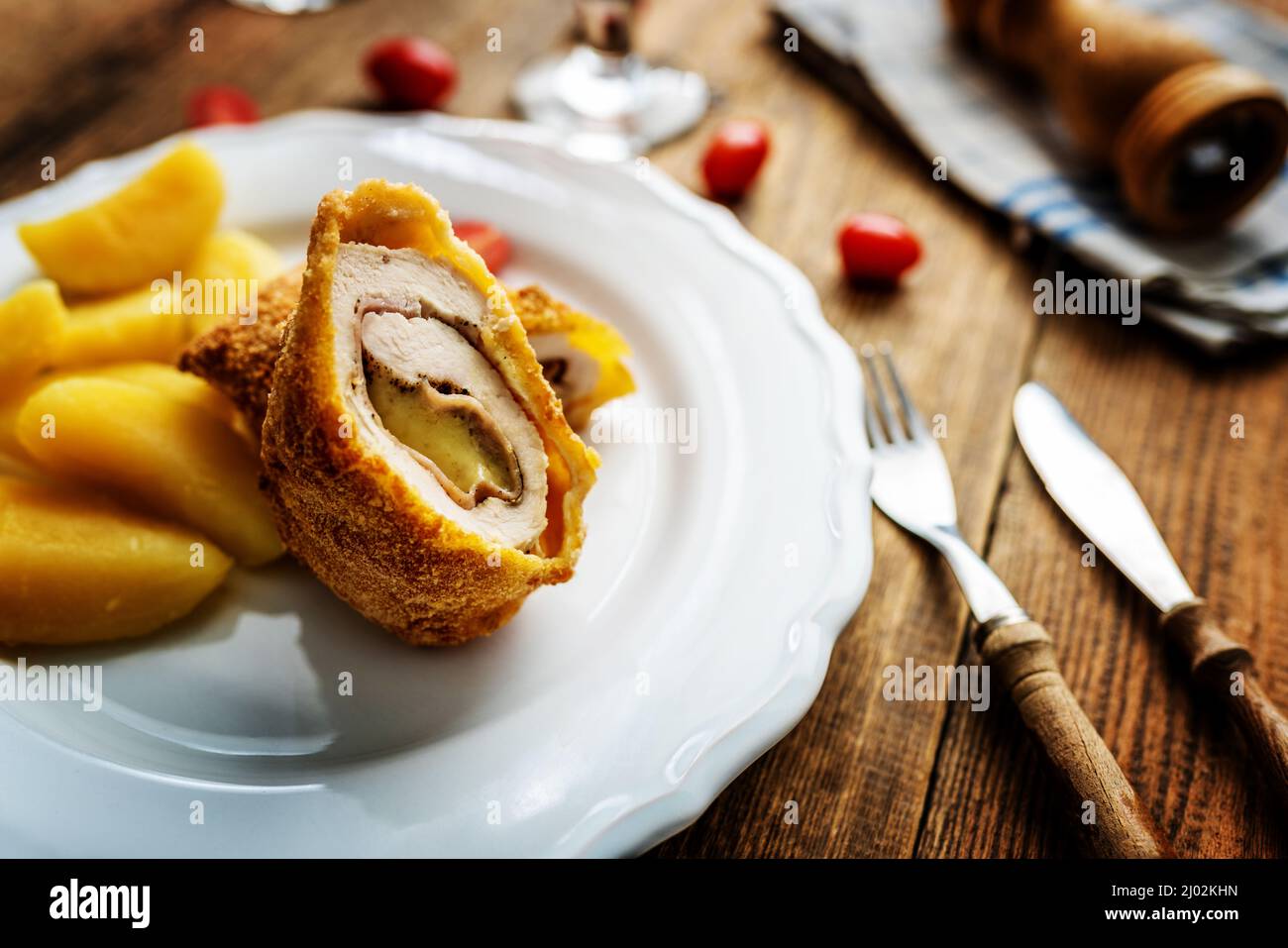 Traditional french cuisine chicken roll Cordon bleu or Gordon blue with cheese, ham and potatoes Stock Photo