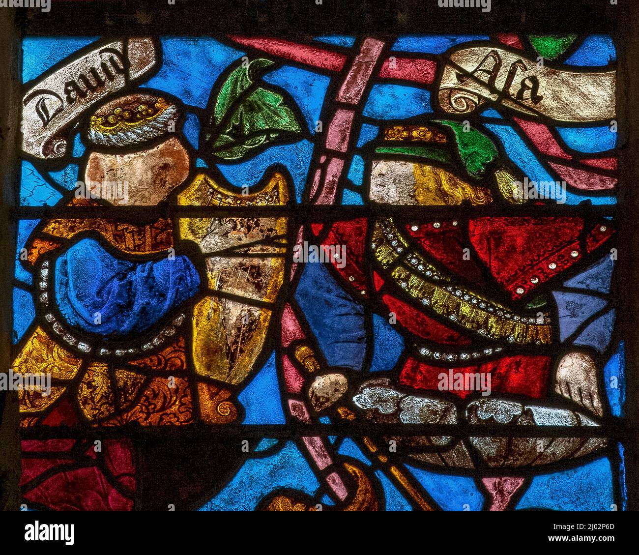 King David of ancient Israel and Judah plays a golden harp in a detail of a colourful stained glass Tree of Jesse, a visual guide to the ancestors of Christ.  Other kings, identified by their crowns and sceptres, are among more than 40 biblical characters supported by daisy-like blossoms sprouting from the tree's branches.  Stained glass of 1512 in the Église Saint-Rémi at Ceffonds, a village in the Champagne region. Stock Photo