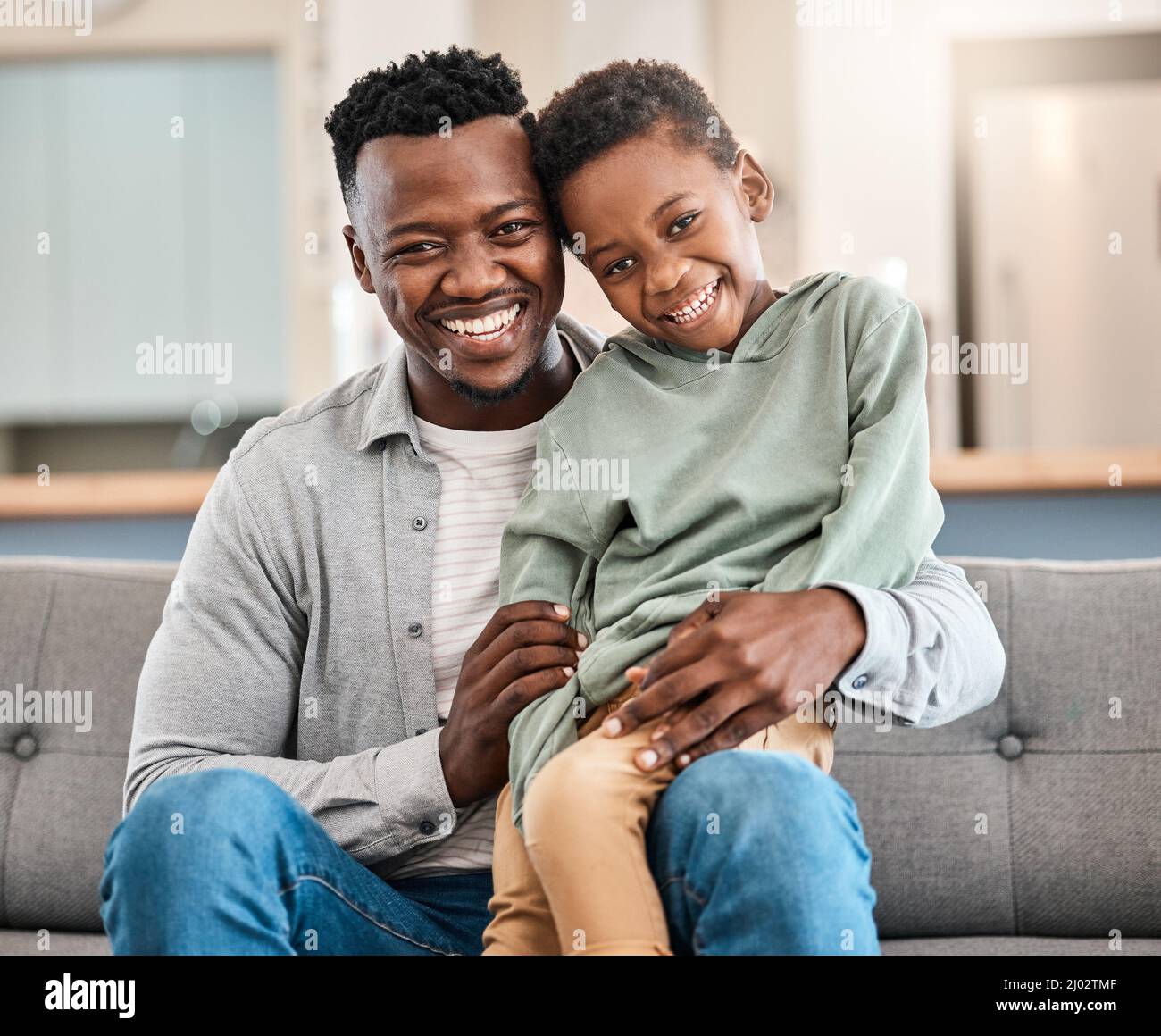 Nothing fosters security than kids who feel loved. Shot of an adorable little boy spending quality time with his father on the sofa at home. Stock Photo