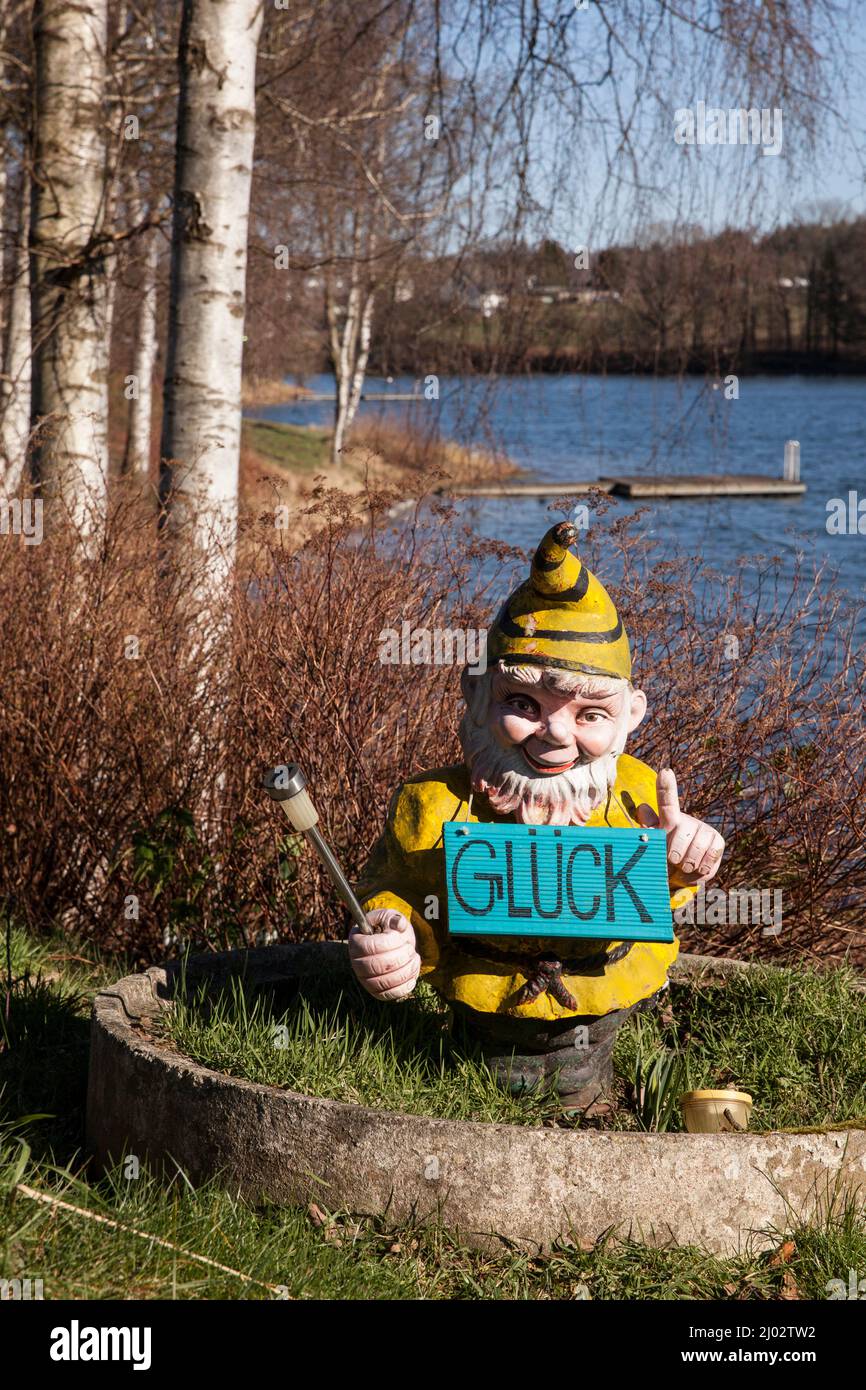 garden gnome with sign that says luck on a campsite at the Bevertal reservoir near Hueckeswagen in the Bergisches Land region, North Rhine-Westphalia, Stock Photo