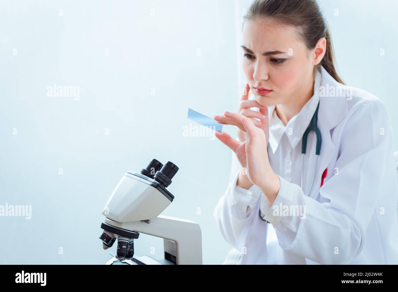 Scientist doctor look at Microscope slide with shock surprised expression form virus mutation test results Stock Photo