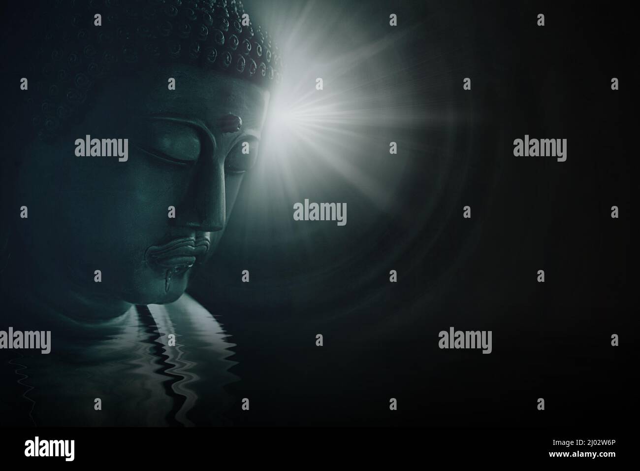 Asian buddha face enlightening wisdom with peace and calm bright light on darkness background. Stock Photo