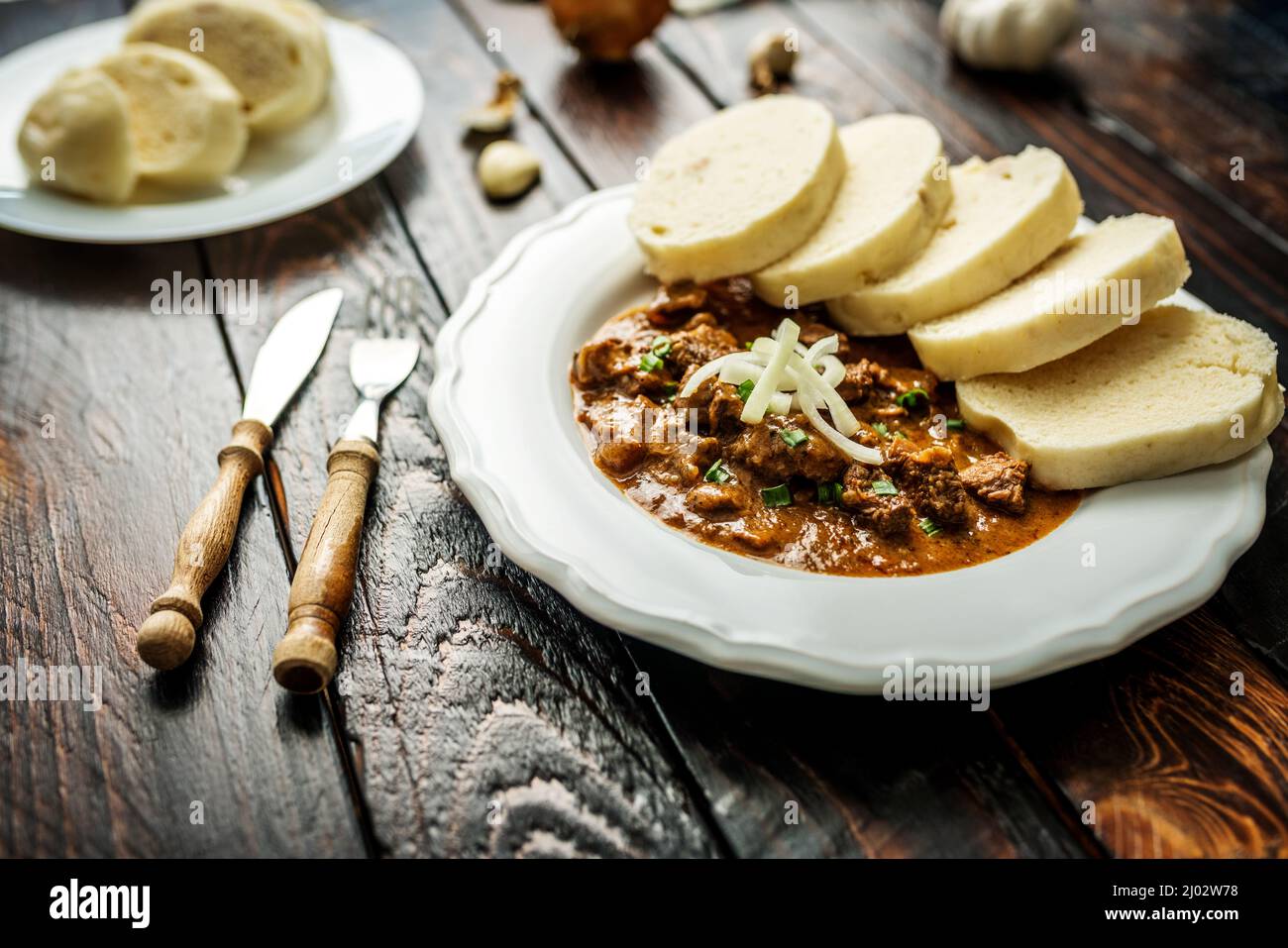 Traditional czech goulash with dumplings and beer on wooden table Stock Photo