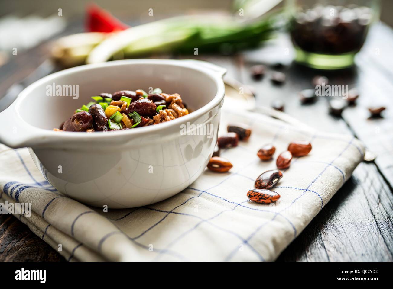 Mexican chili or chilli con carne. Cooked kidney bean, minced meat, chili, corn and pepper in pan  on wood table Stock Photo