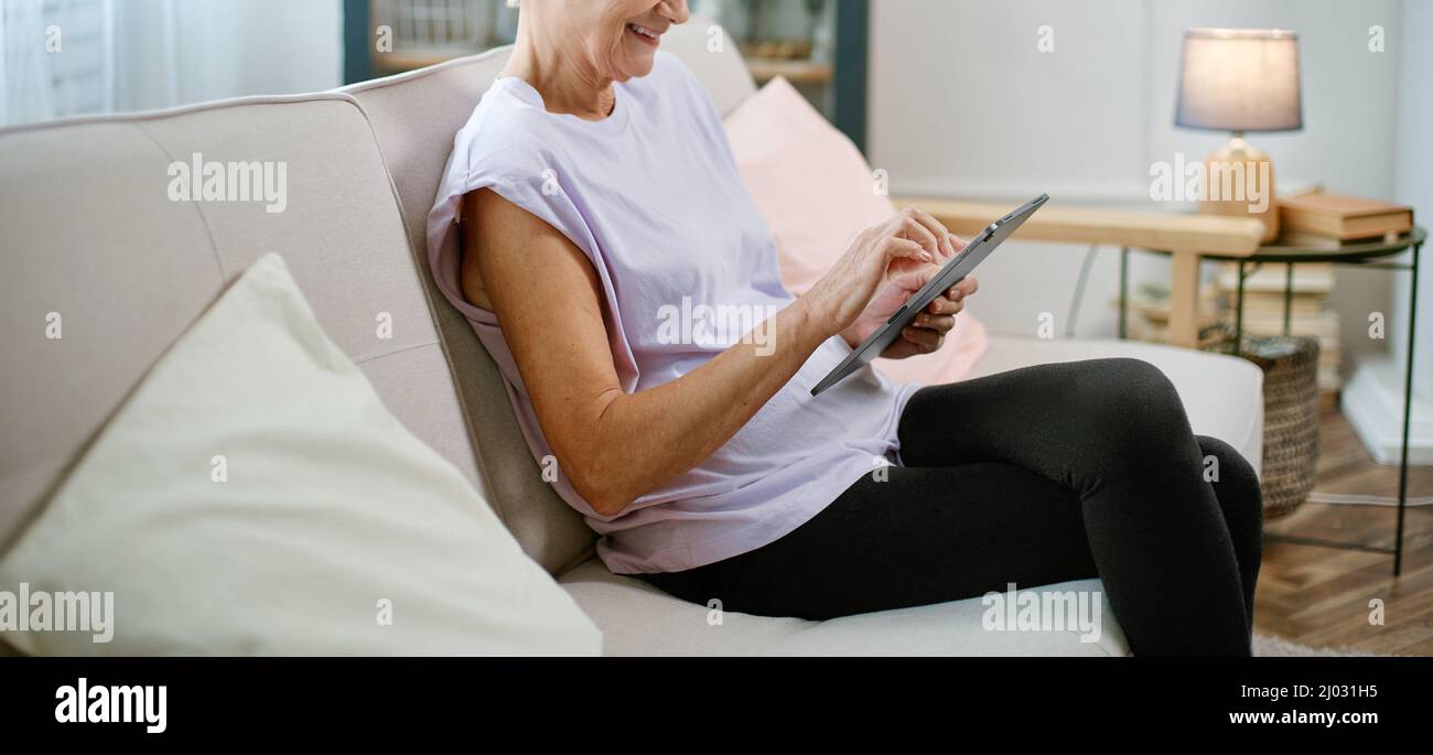 elderly woman looking at the screen of her digital tablet . Stock Photo