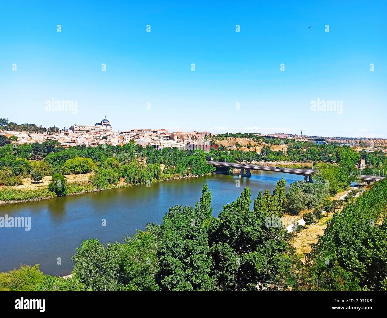 Beautiful view of Tagus river flowing through Toledo, Spain, with trees ...