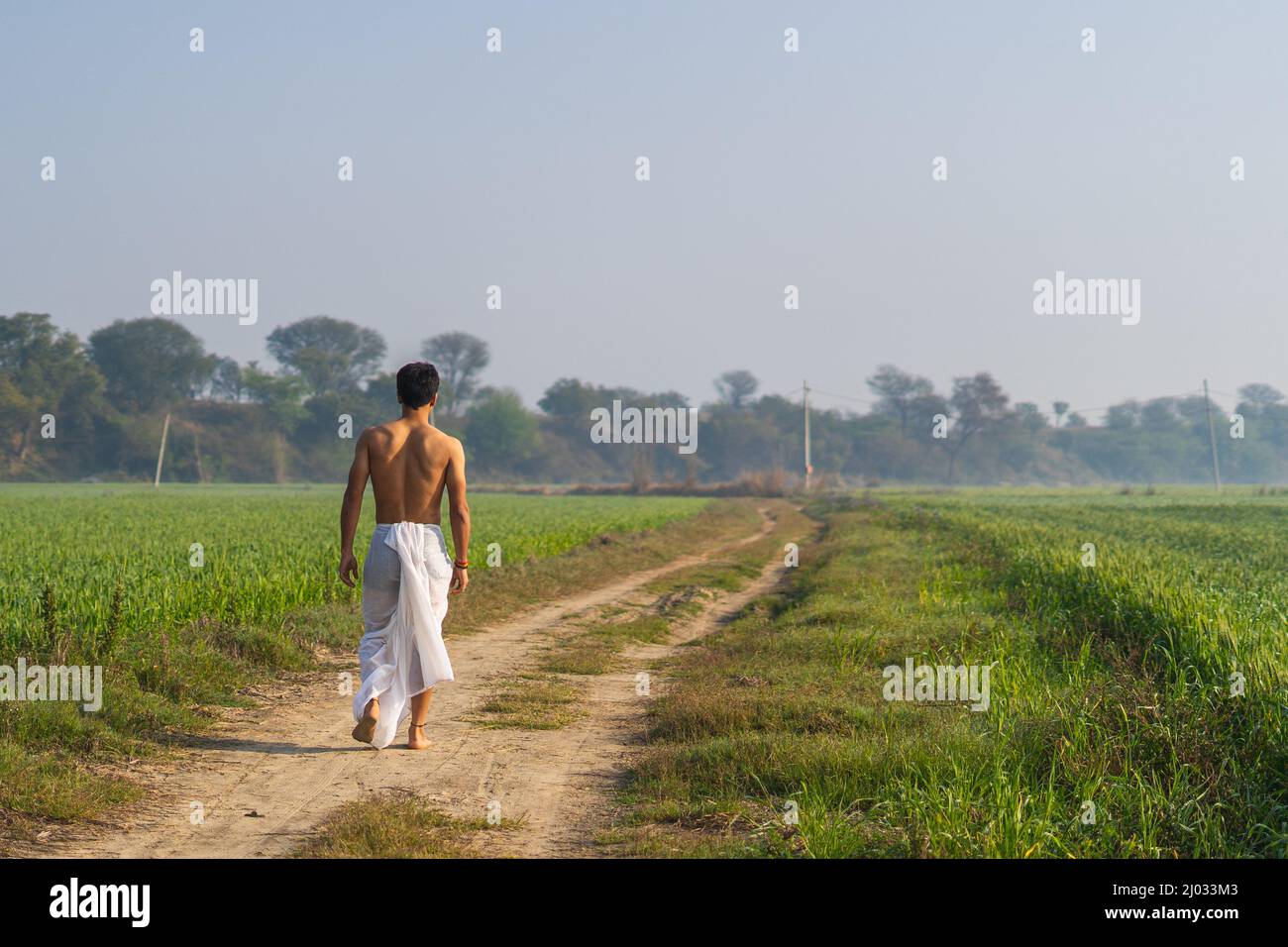 Young Indian male walking in the fields Stock Photo