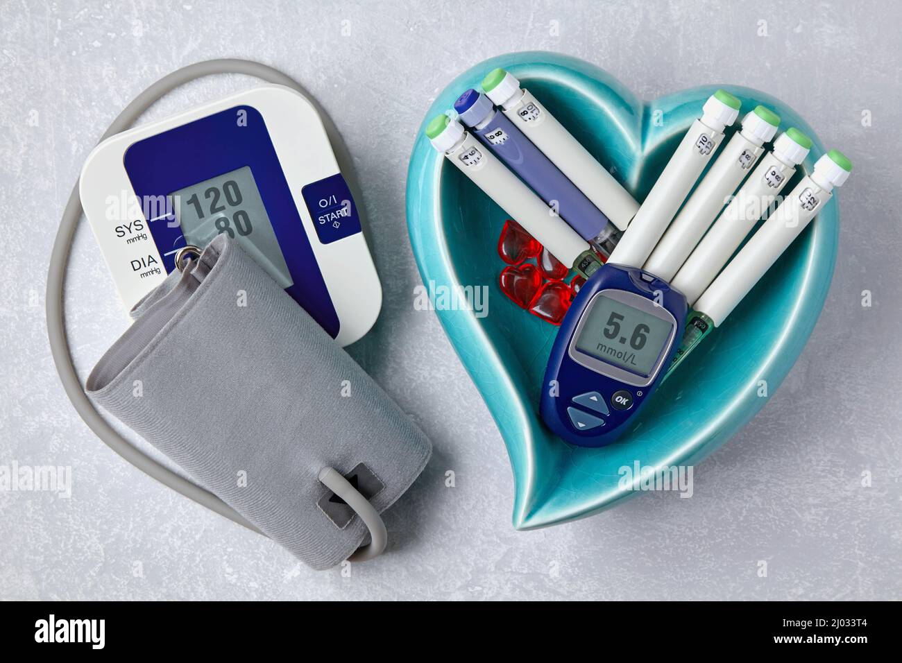 https://c8.alamy.com/comp/2J033T4/blood-pressure-monitor-blood-glucose-monitor-insulin-syringe-pens-in-a-blue-heart-shaped-bowl-on-a-light-gray-concrete-table-medical-equipment-for-2J033T4.jpg