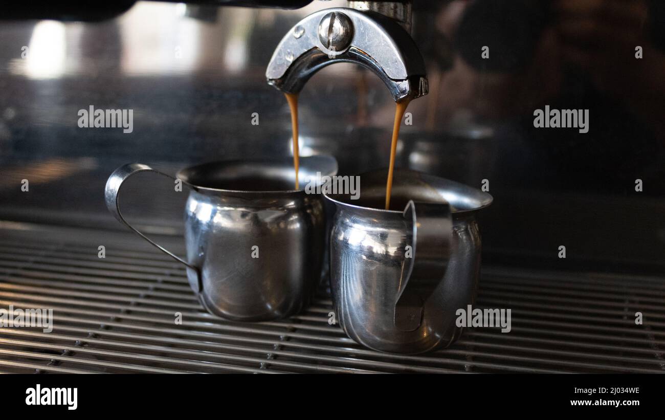 coffee machine dripping coffee into two metal cups Stock Photo Alamy