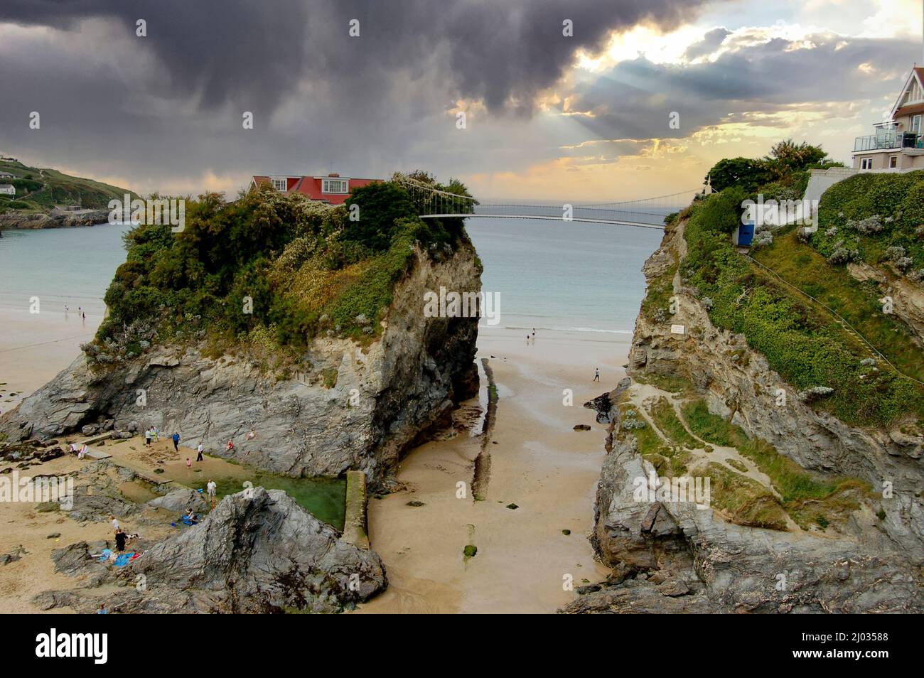 Newquay island, Cornwall. A small footbridge reaching across to a solitary house. Picturesque sandy bay. Stock Photo