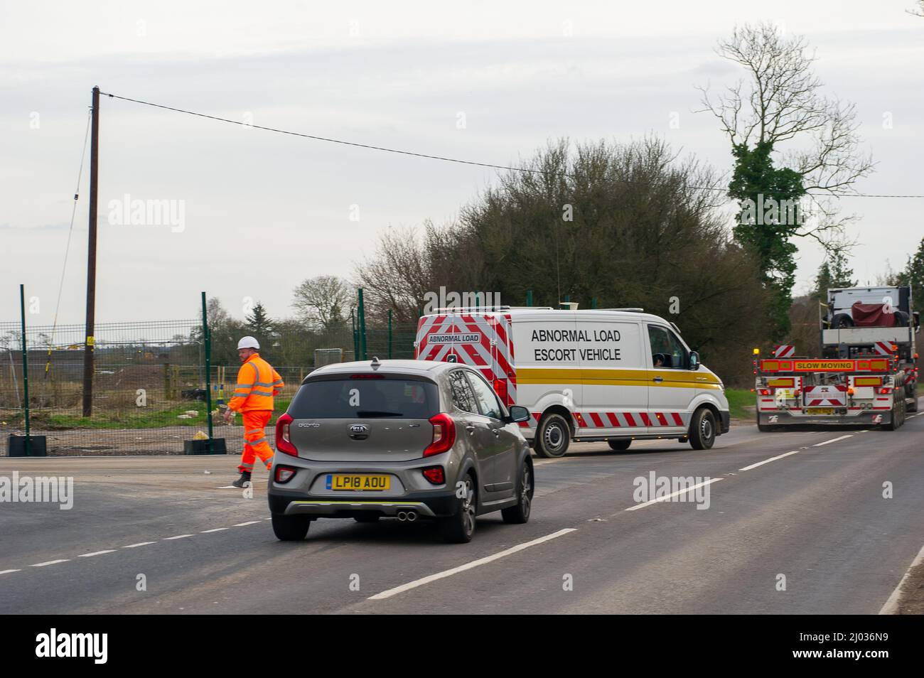 Wendover, Buckinghamshire, UK. 15th March, 2022. An abnormal load is escorted from an HS2 site onto the A413. The High Speed Rail construction work on the new railway between London and Birmingham, has meant a big increase in the number of lorries using roads across Buckinghamshire. Credit: Maureen McLean/Alamy Live News Stock Photo