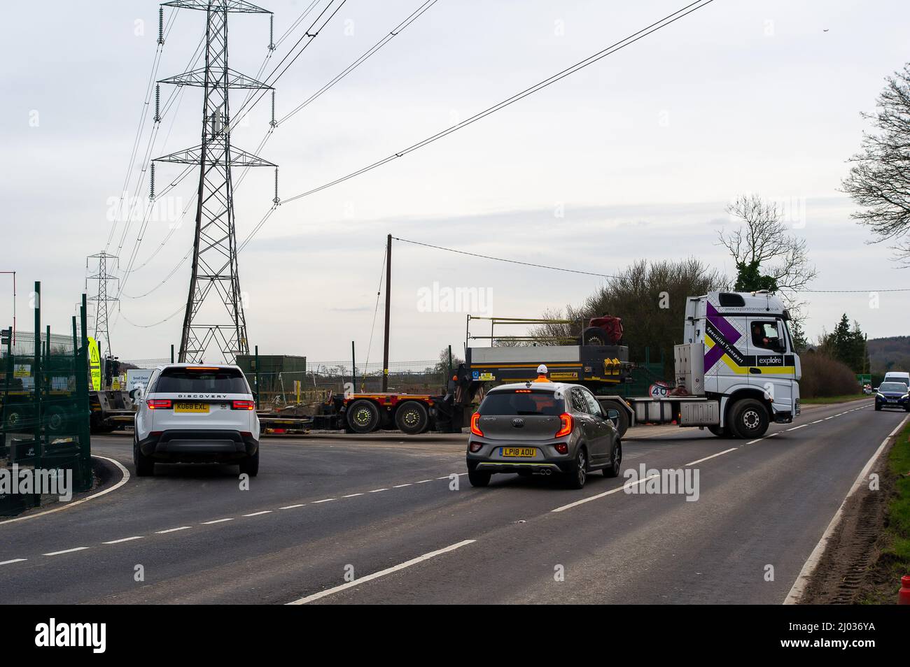 Wendover, Buckinghamshire, UK. 15th March, 2022. An abnormal load is escorted from an HS2 site onto the A413. The High Speed Rail construction work on the new railway between London and Birmingham, has meant a big increase in the number of lorries using roads across Buckinghamshire. Credit: Maureen McLean/Alamy Live News Stock Photo