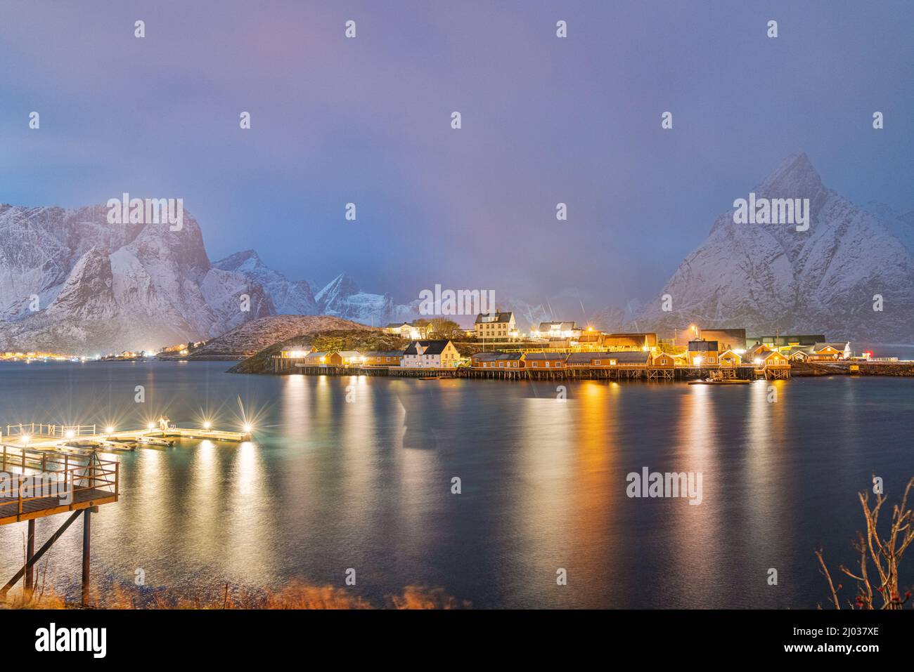 Illuminated Rorbu and houses in night fog during the cold winter, Sakrisoy, Reine, Nordland county, Lofoten Islands, Norway, Scandinavia, Europe Stock Photo