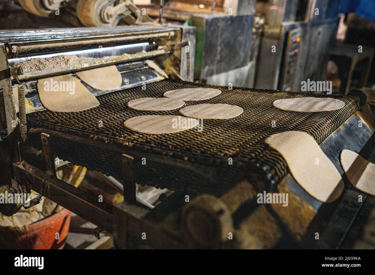 Fresh Roti being made on a conveyor belt at the Golden Temple, Amritsar, Punjab, India, Asia Stock Photo