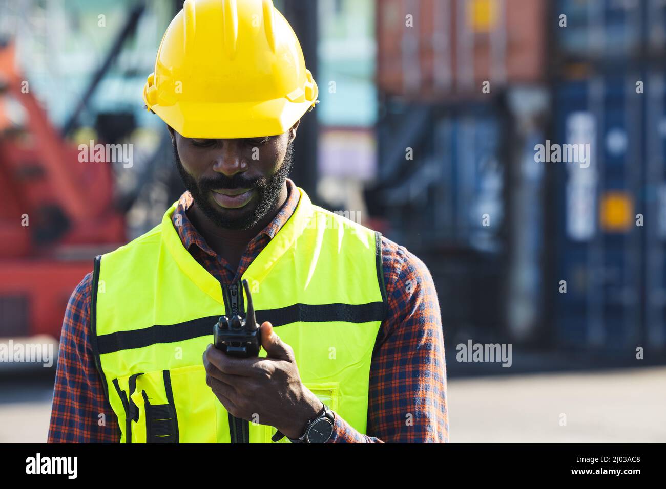 Logistics staff worker working with radio call control loading container at cargo port. Stock Photo