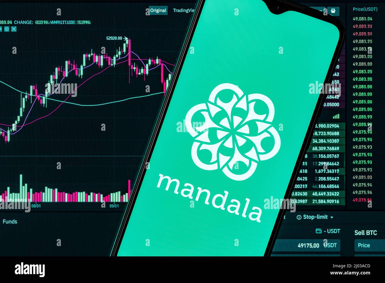 A smartphone with the Mandala exchange logo on the background of the live trading webpage. Mandala exchange dashboard. Stock Photo