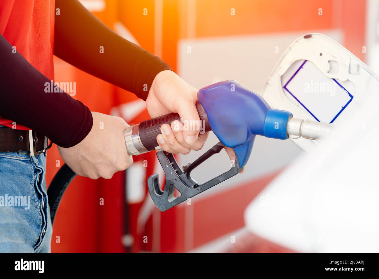 Gas station staff worker full fill car fuel. closeup gasoline fuel dispenser nozzle holder. Stock Photo