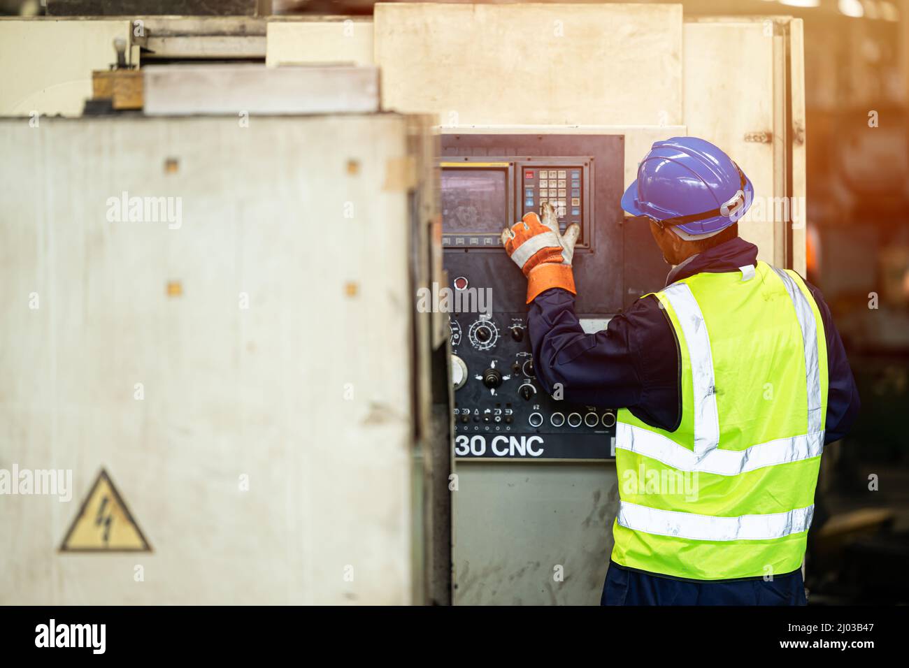 Professional engineer staff worker operate CNC machine working in heavy metal industry factory. Stock Photo