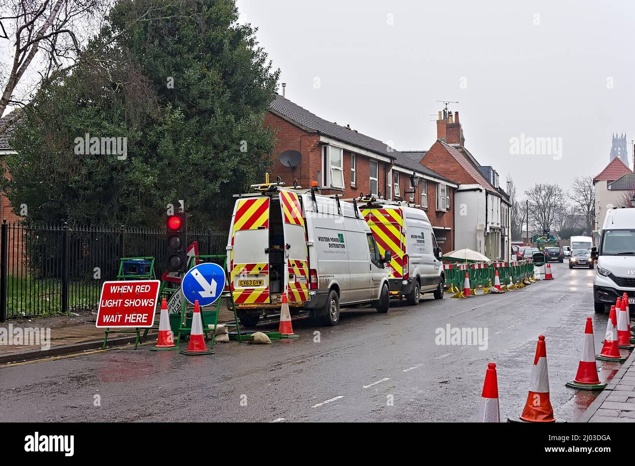 Roadworks with green barriers and maintenance vans on the High street Stock Photo
