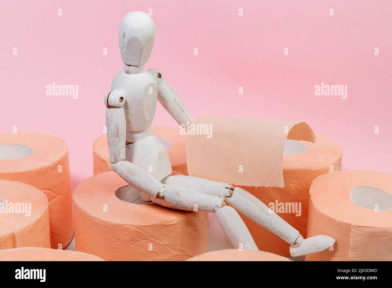 Toilet paper orange color with wooden maneken. Toiletries and