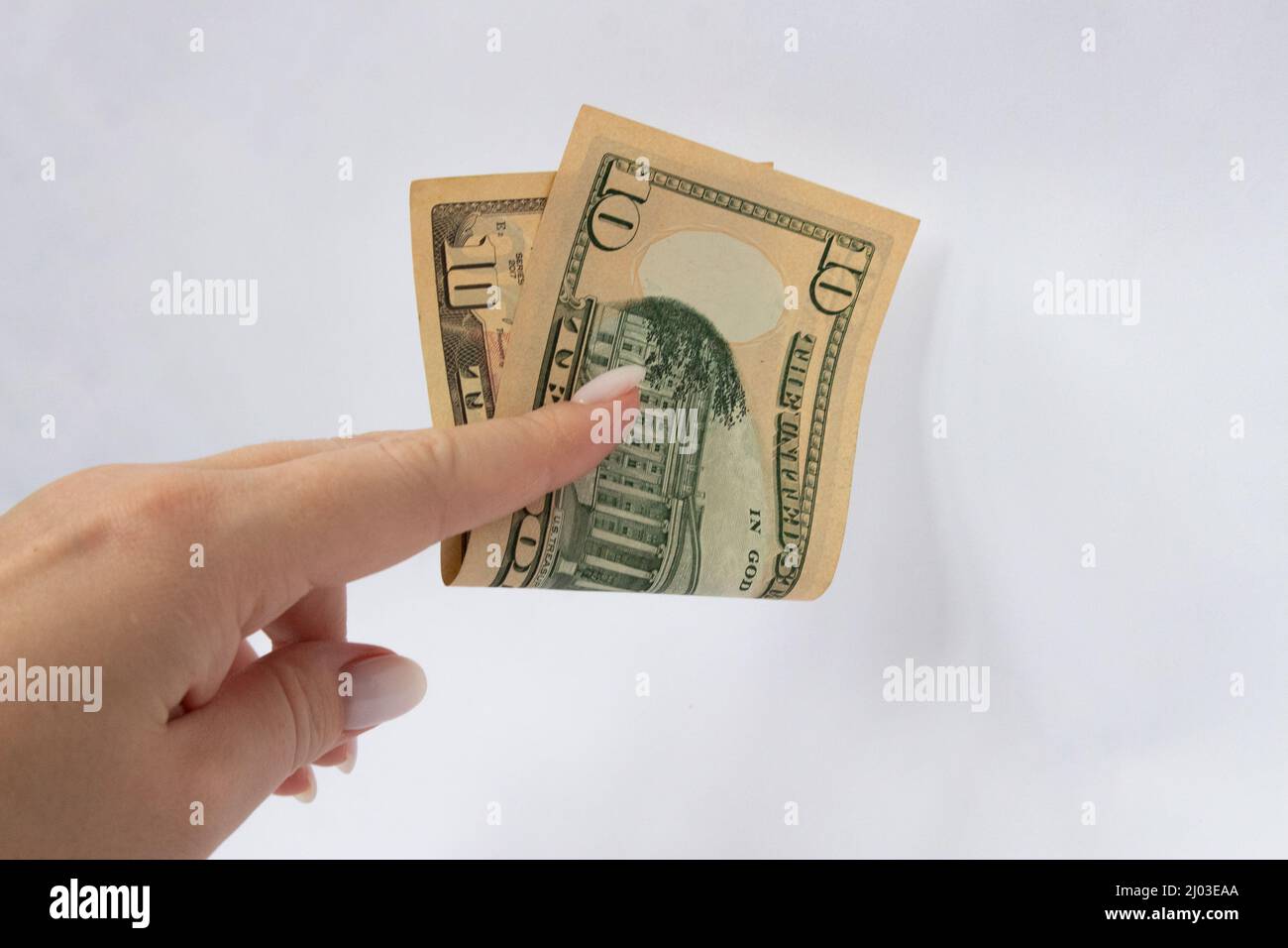 10 dollars in the hand close-up on a white isolated background. A ten-dollar bill Stock Photo