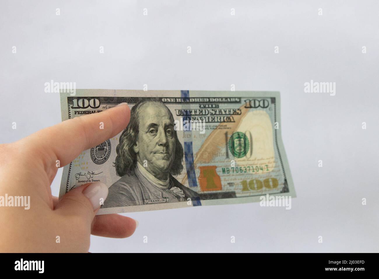100 dollars in hand close-up on a white isolated background. One hundred dollar bill Stock Photo