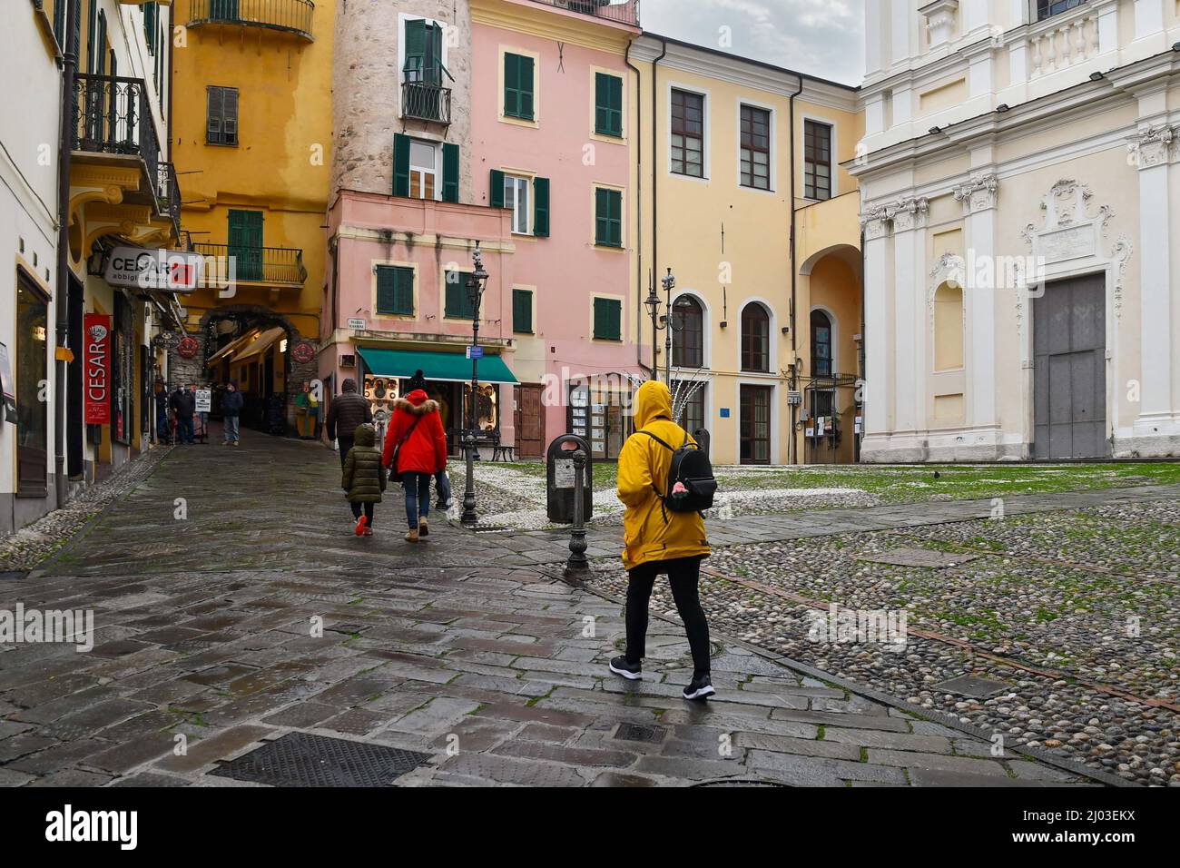 Tourists walking in front of the church of St Stephen in the old town of Sanremo in a rainy day, Imperia, Liguria, Italy Stock Photo