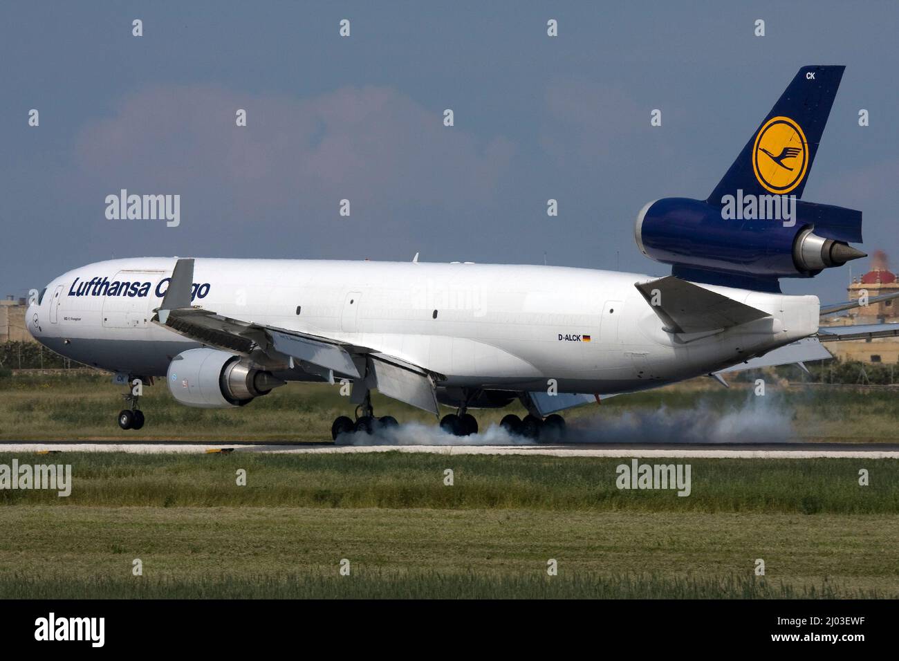 Lufthansa Cargo McDonnell Douglas MD-11F (REG: D-ALCK) touching down and burning rubber on runway 31. Stock Photo