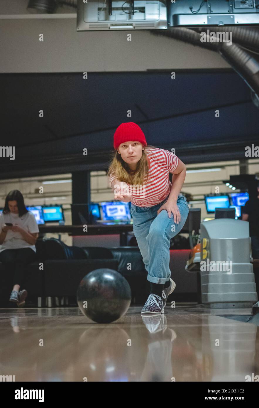 Professional female bowler throws his throw and is in position to watch his ball. Bowling life