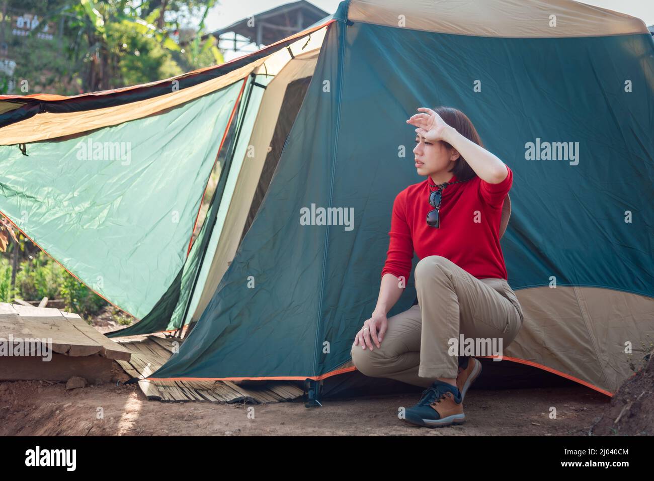 An Asian woman is tired while pitching a tent at Hadubi viewpoint, Chiang Mai, Thailand. Stock Photo