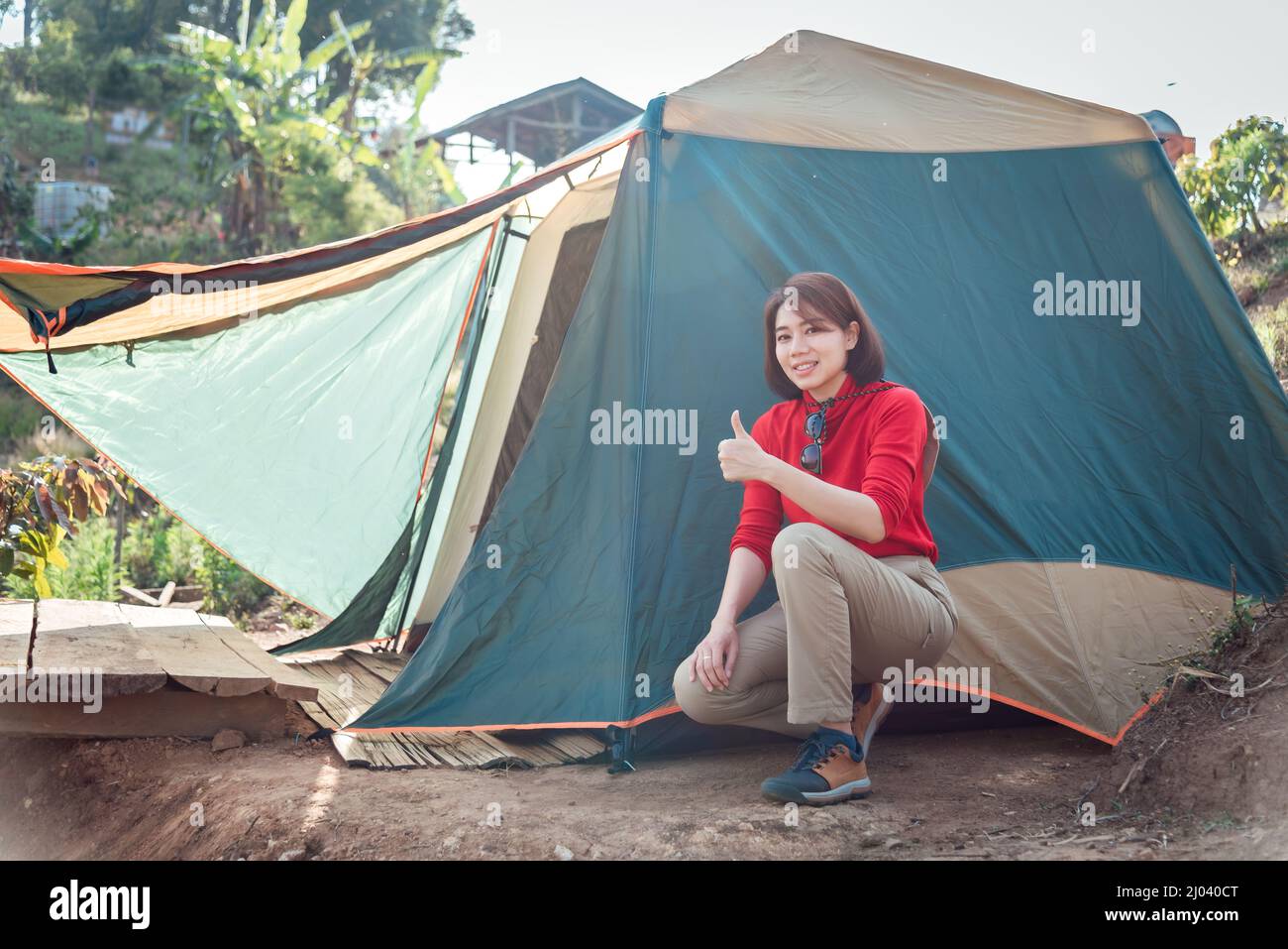 An Asian woman is thumbs up show how easy to pitch a tent at Hadubi viewpoint, Chiang Mai, Thailand. Stock Photo