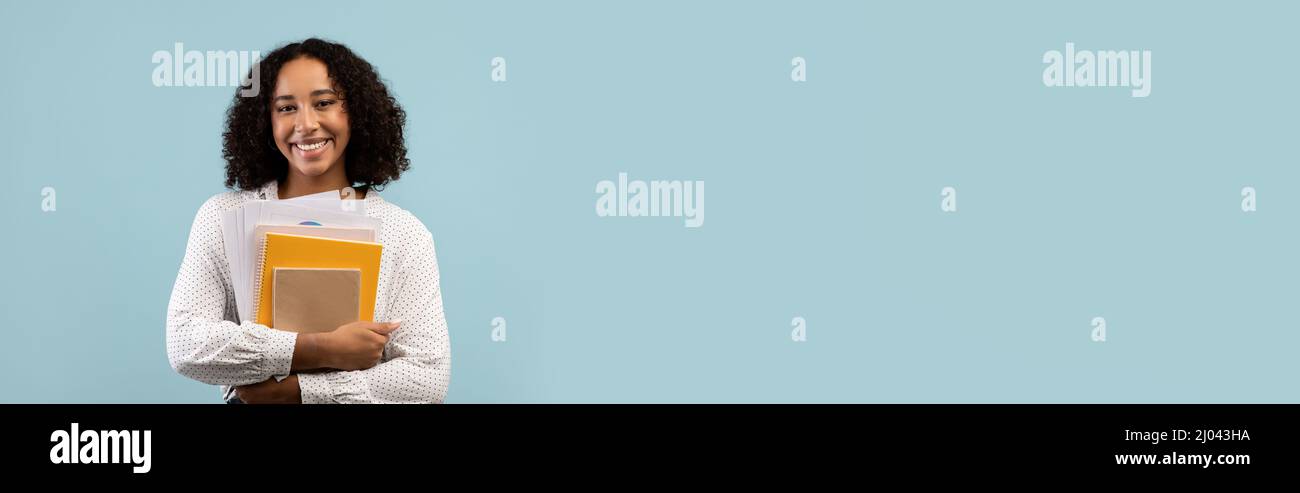 Positive african american woman student with books Stock Photo - Alamy