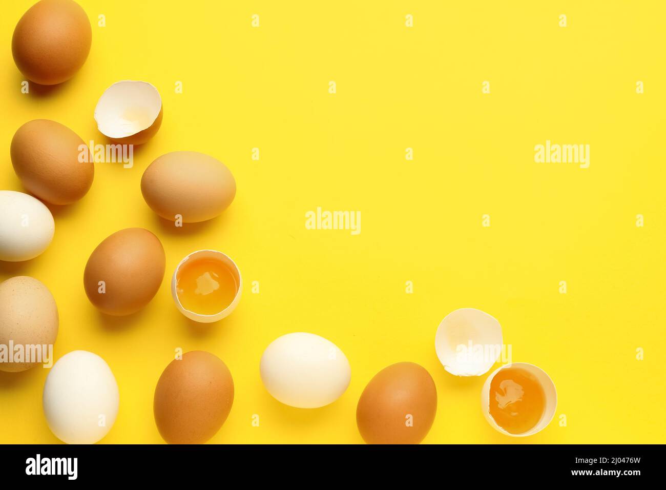 Cracked and whole chicken eggs on yellow background Stock Photo - Alamy