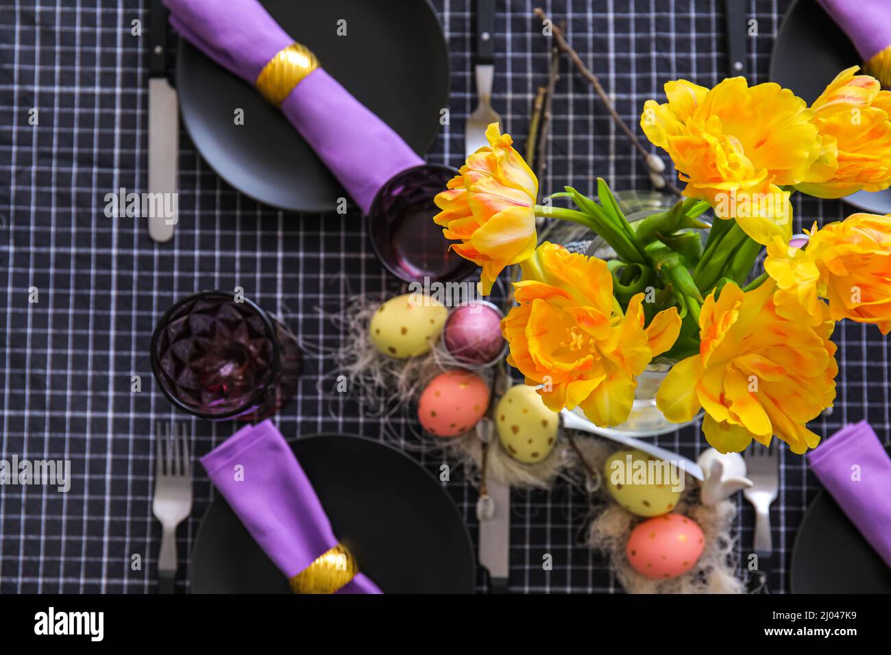 Bouquet of yellow tulips on table served for Easter celebration Stock ...