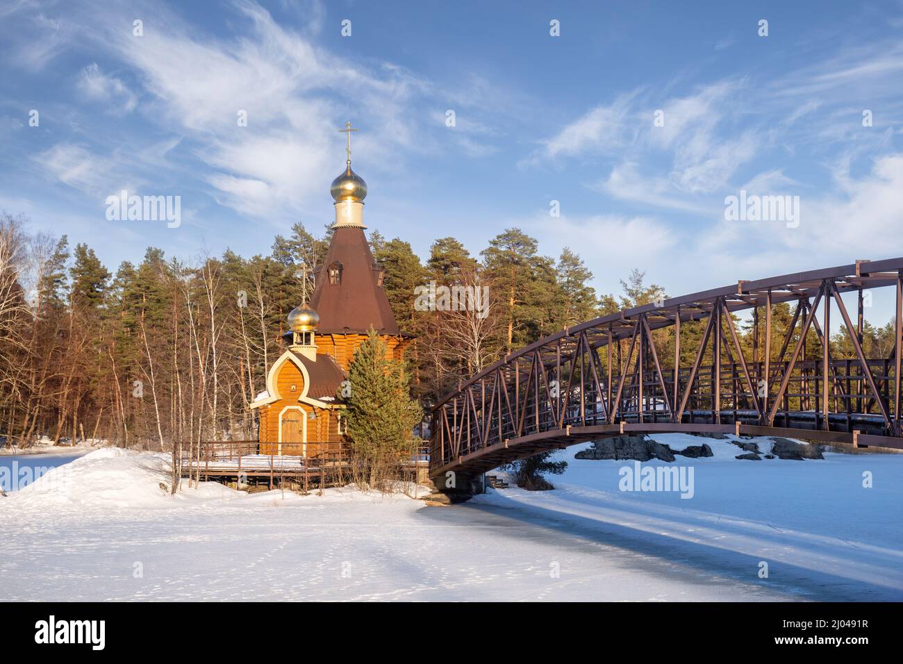 Small wooden church of St. Andrew the First-Called on the island of the Vuoksa River. Winter sunny landscape, early spring. Leningrad region, Russia Stock Photo