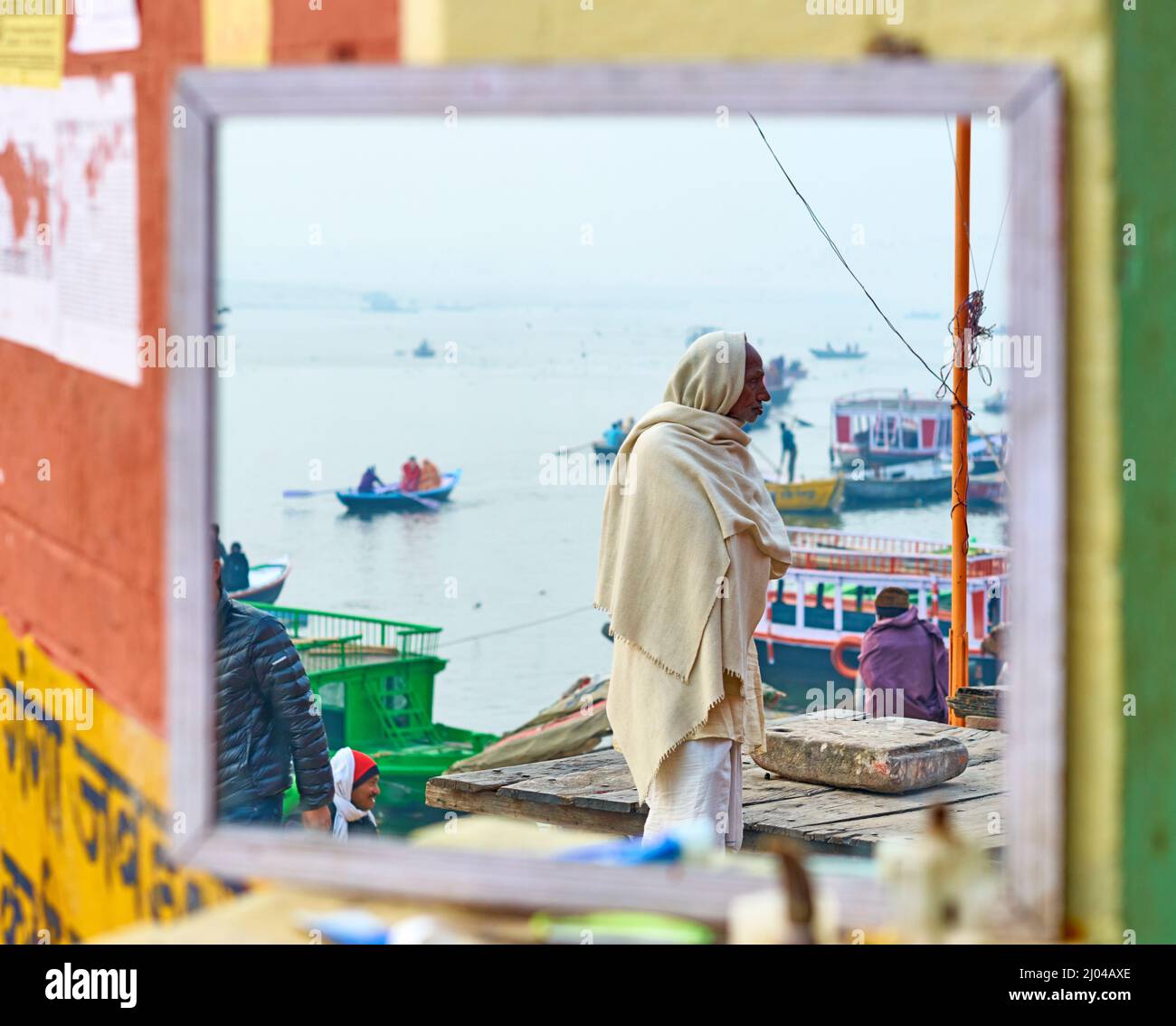 India. Varanasi Benares Uttar Pradesh. Man reflected in a mirror by the river Ganges Stock Photo