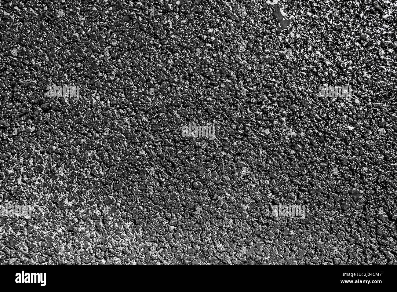 The texture of fresh asphalt of dark color wet from water and shiny