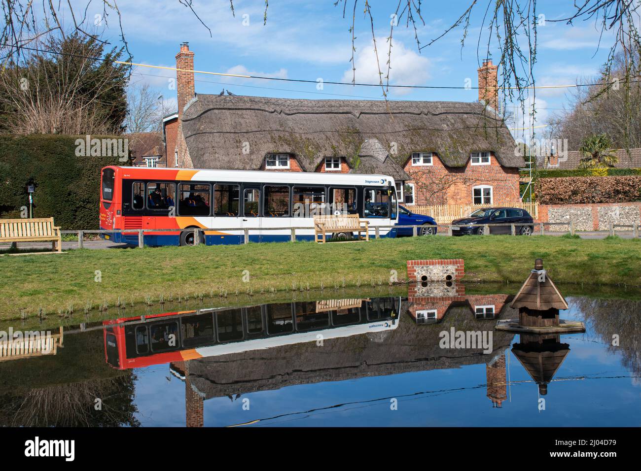 Oakley village in Hampshire, England, UK, with a Stagecoach bus driving by the duck pond Stock Photo