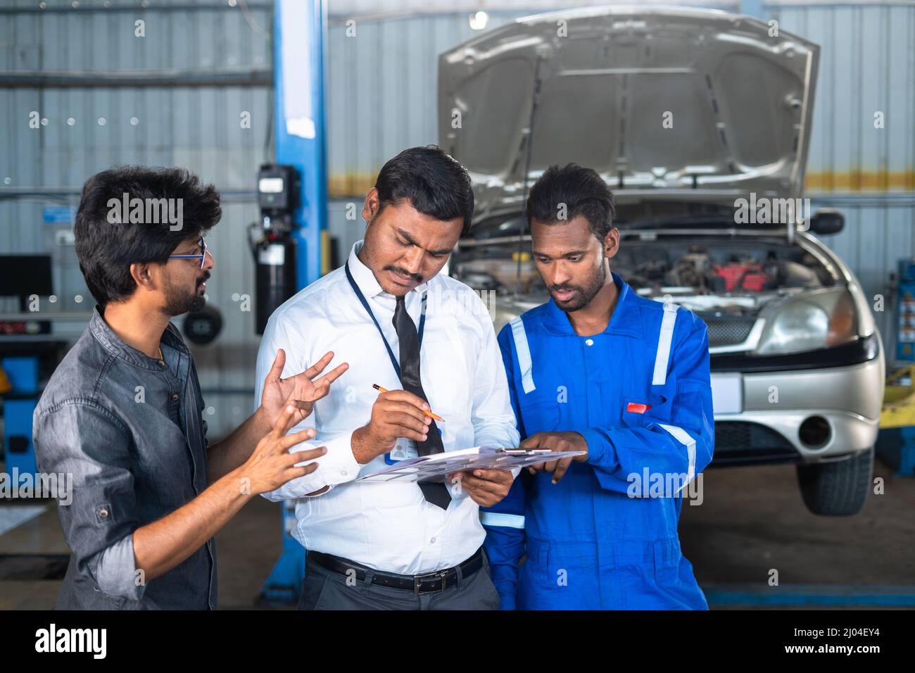 Customer discussing with Mechanic and garage executive about car