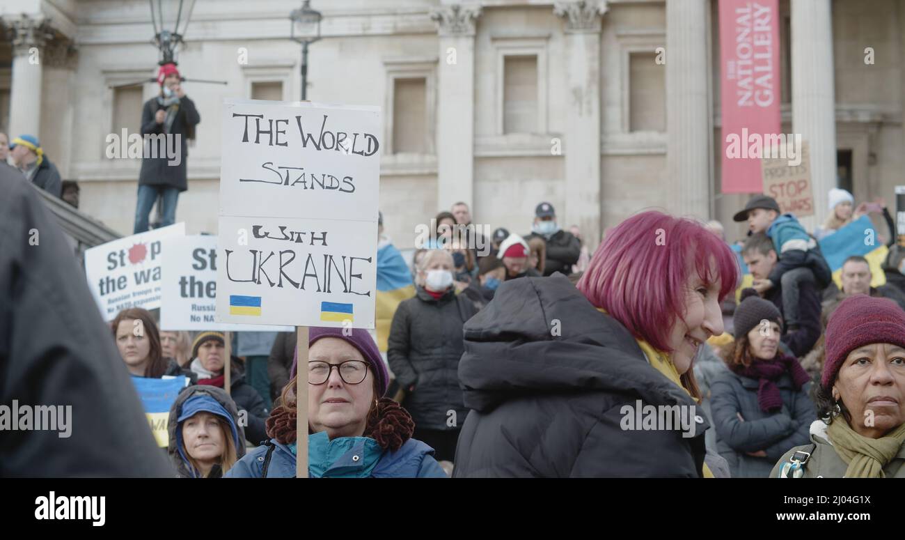 London, UK - 03 06 2022:  Woman protester at Trafalgar Square holding a sign, ‘The World Stands With Ukraine’, showing UK support for Ukrainian people. Stock Photo