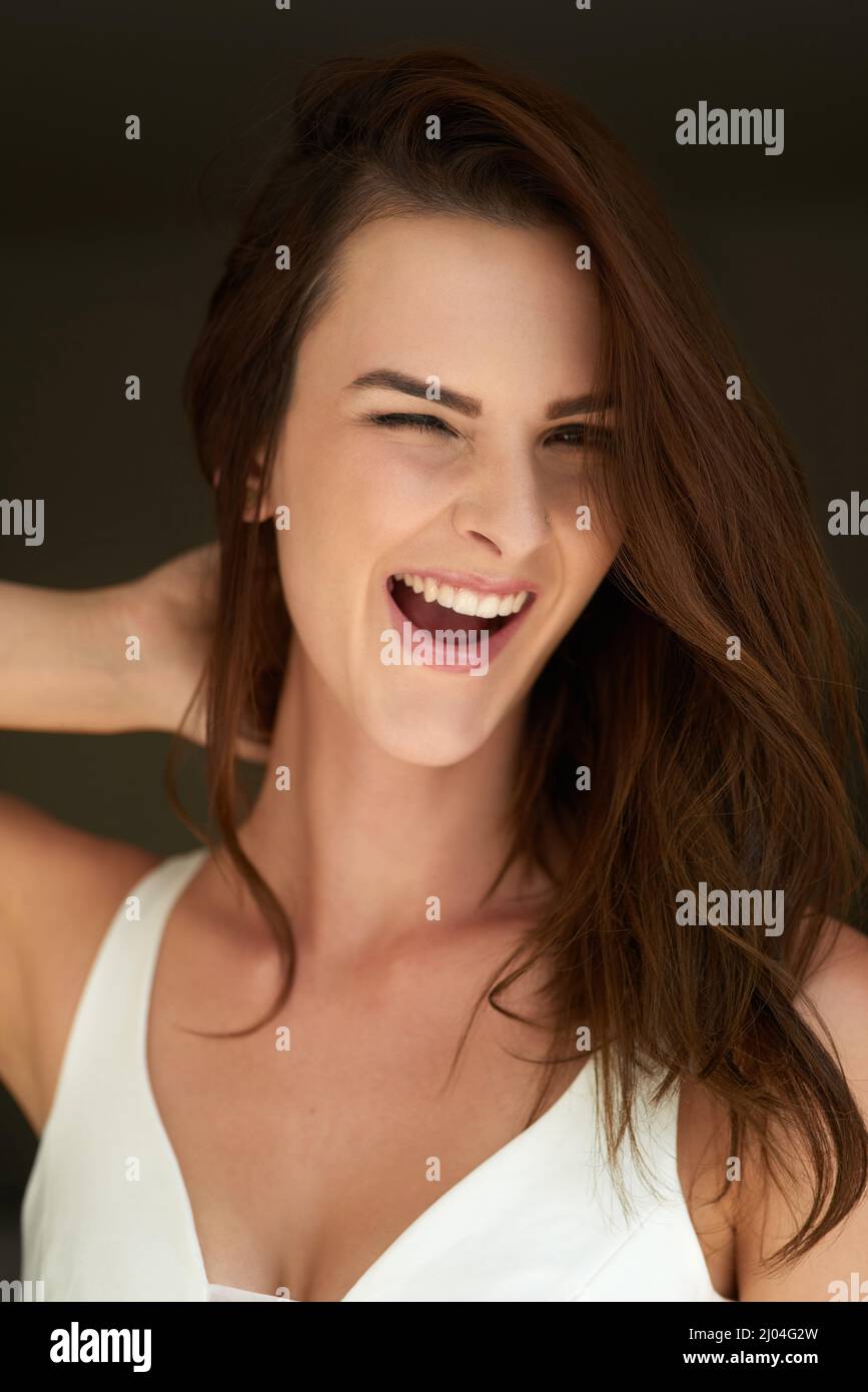 Do you like what you see. Studio portrait of an attractive young woman winking against a black background. Stock Photo
